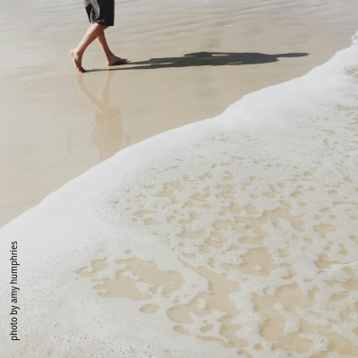 Person geht am Strand entlang 